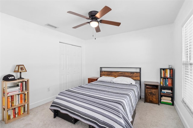 carpeted bedroom with a closet and ceiling fan