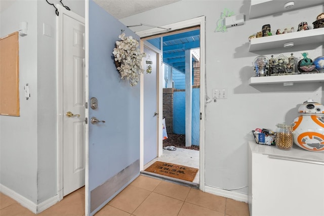 doorway with light tile patterned floors and a textured ceiling