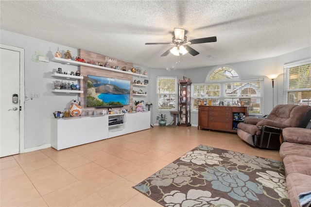 living room featuring light tile patterned floors, a textured ceiling, and ceiling fan