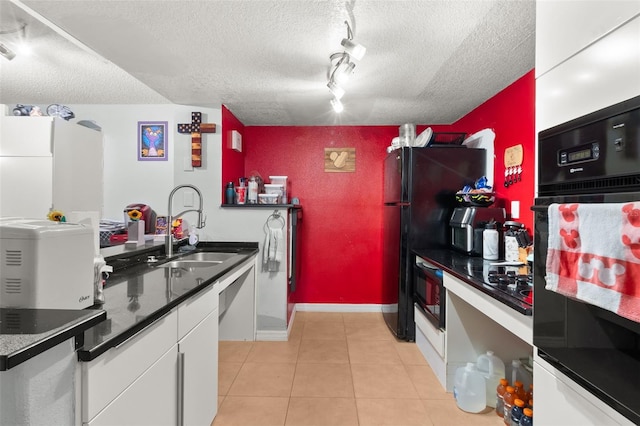 kitchen with white cabinets, black appliances, sink, and a textured ceiling