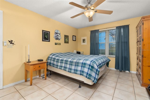 tiled bedroom with ceiling fan and a textured ceiling