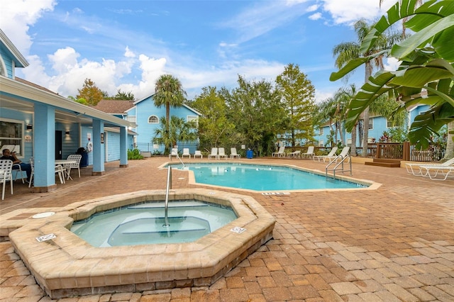 view of pool with a patio and a hot tub