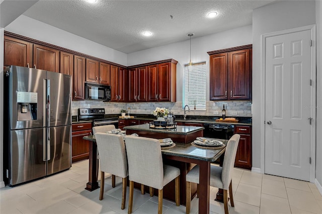 kitchen featuring backsplash, a textured ceiling, sink, black appliances, and decorative light fixtures