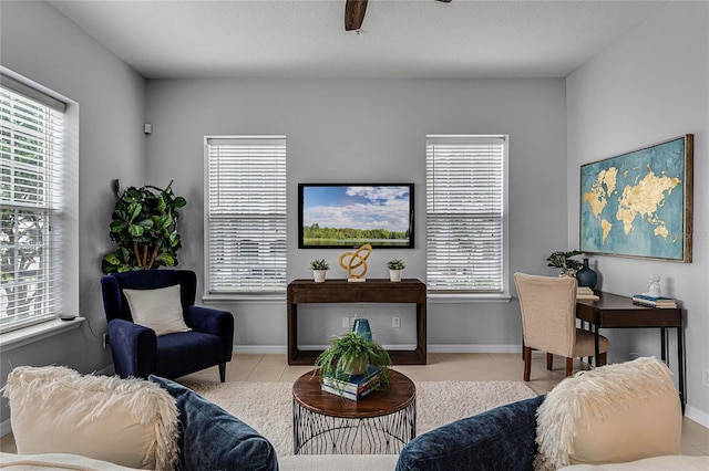 living room featuring light tile patterned floors, ceiling fan, and a healthy amount of sunlight