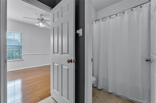 bathroom featuring hardwood / wood-style floors, ceiling fan, toilet, and a textured ceiling