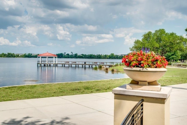 dock area featuring a water view and a lawn