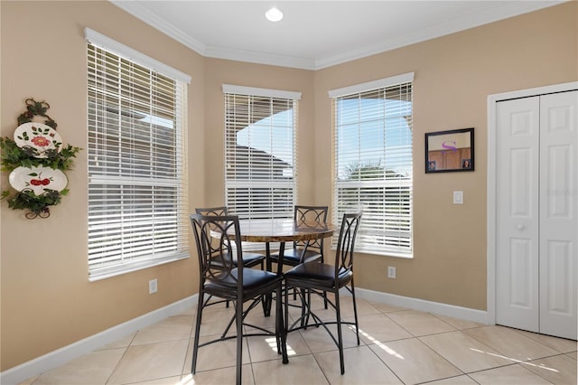 dining space featuring light tile patterned flooring, crown molding, and baseboards