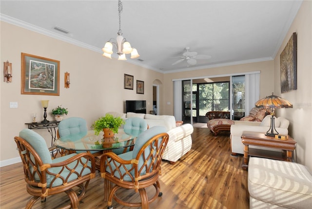 dining area with visible vents, arched walkways, wood finished floors, and ornamental molding