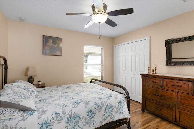 bedroom with light wood-type flooring, a closet, and ceiling fan