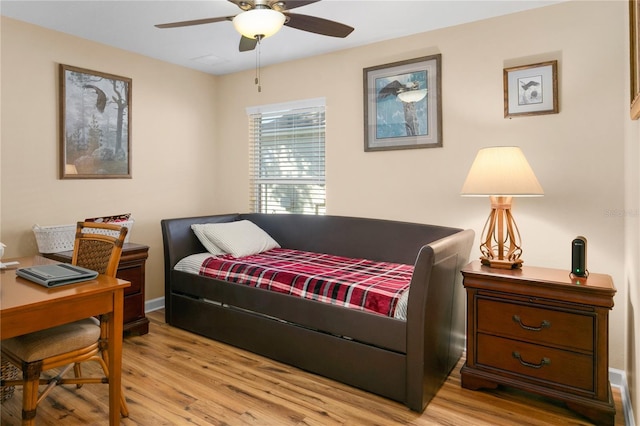 bedroom with light wood-style flooring, baseboards, and ceiling fan