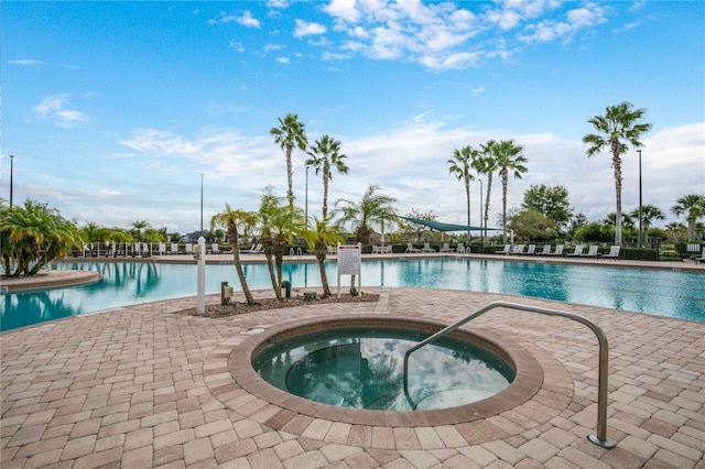 community pool with a community hot tub and a patio area