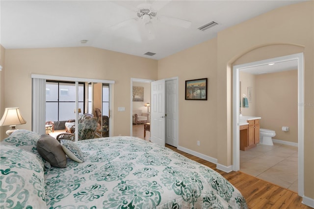 bedroom featuring lofted ceiling, light wood-style flooring, visible vents, and baseboards