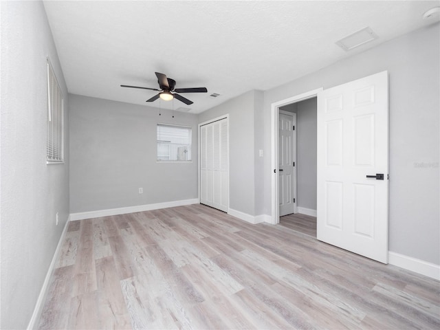 unfurnished bedroom with ceiling fan and light wood-type flooring