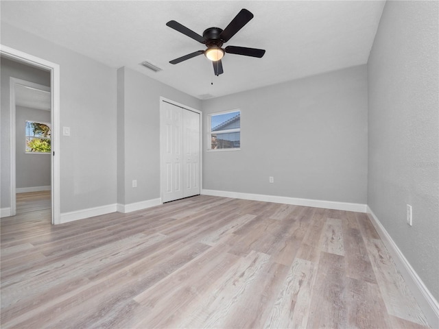 unfurnished bedroom with ceiling fan, light hardwood / wood-style floors, and a closet