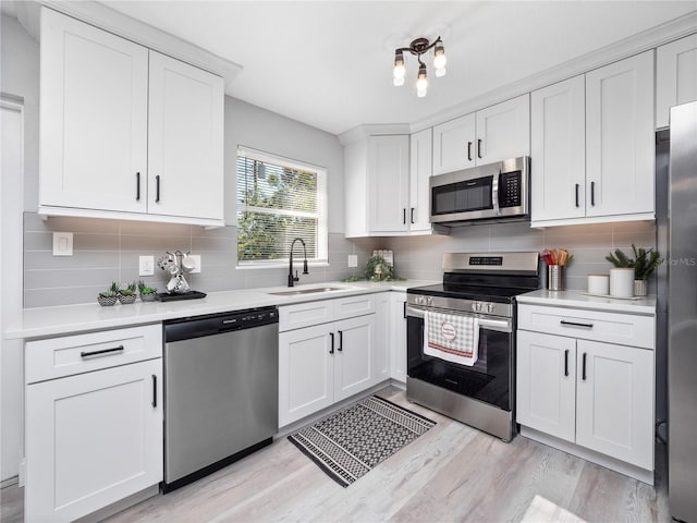 kitchen featuring white cabinets, stainless steel appliances, light hardwood / wood-style flooring, and sink