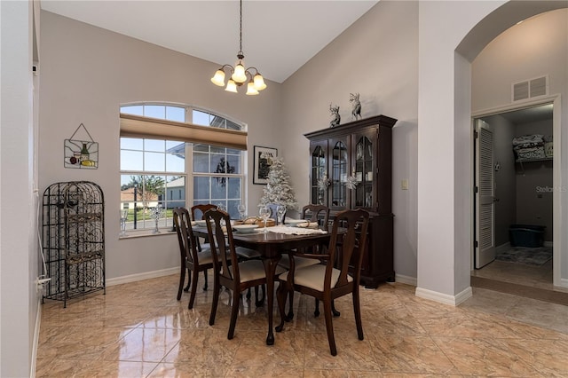 dining space with high vaulted ceiling and a notable chandelier