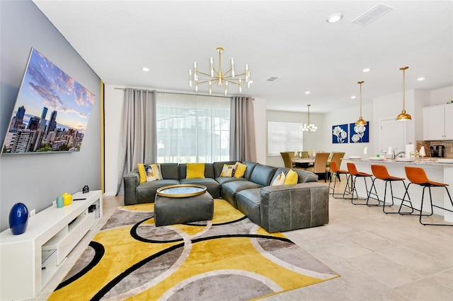 tiled living room featuring sink and a notable chandelier