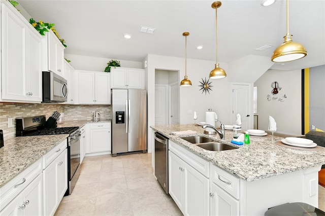 kitchen featuring white cabinets, sink, stainless steel appliances, and an island with sink