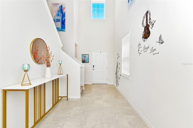 entrance foyer featuring light tile patterned floors and a high ceiling