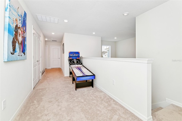 hallway with light colored carpet