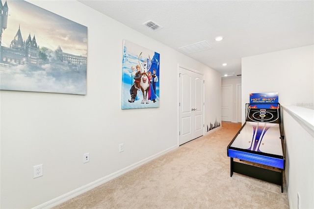 recreation room with light colored carpet