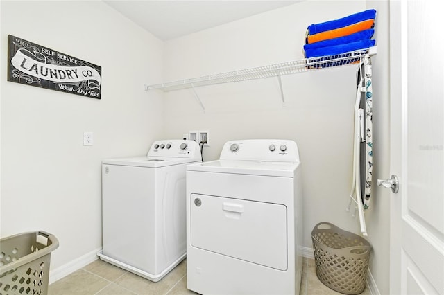 laundry room with washer and dryer and light tile patterned flooring