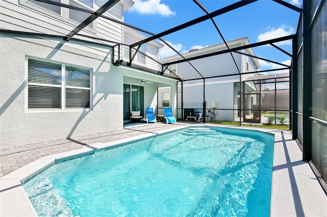 view of swimming pool featuring a patio, ceiling fan, and a lanai