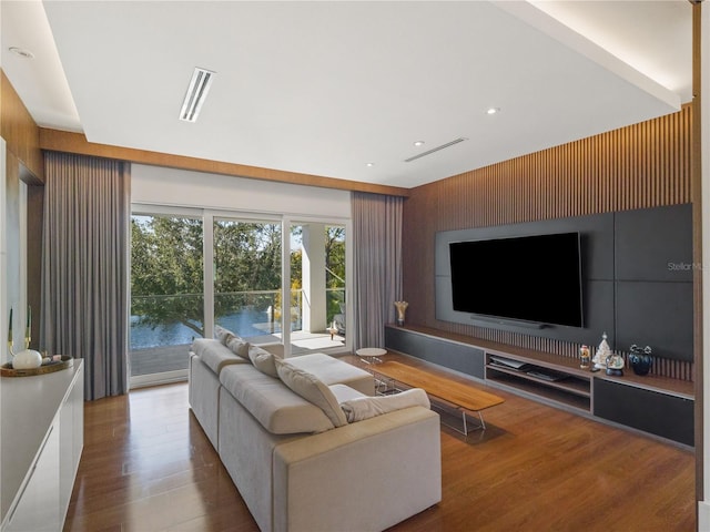 living room with wood walls and wood-type flooring