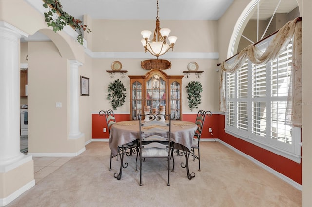 dining area featuring light carpet, a chandelier, and ornate columns