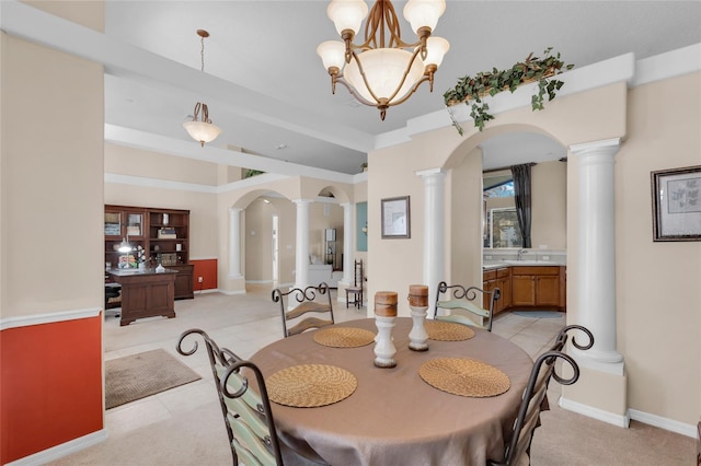 tiled dining area with ornate columns, sink, and a chandelier