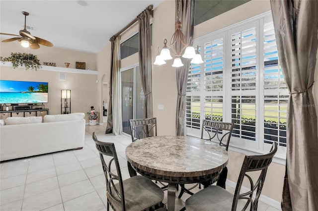 dining space with ceiling fan with notable chandelier and light tile patterned flooring