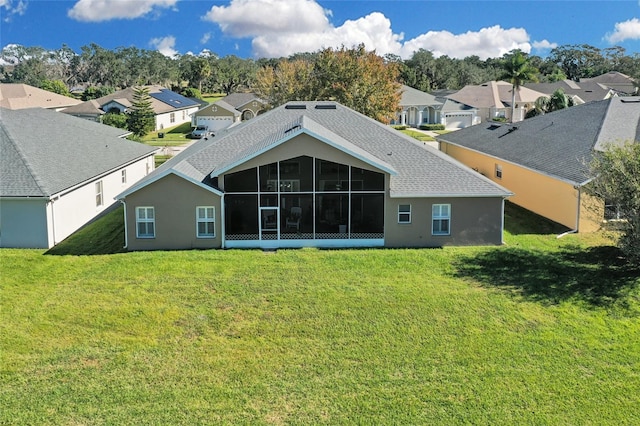 rear view of property featuring a lawn and a sunroom