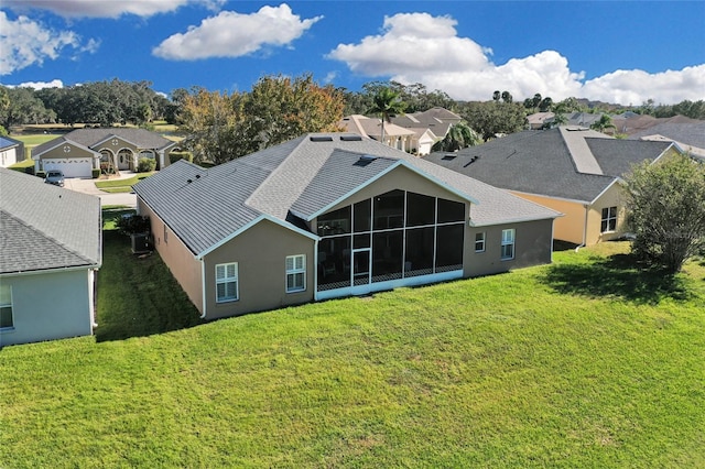 back of house with a yard and a sunroom