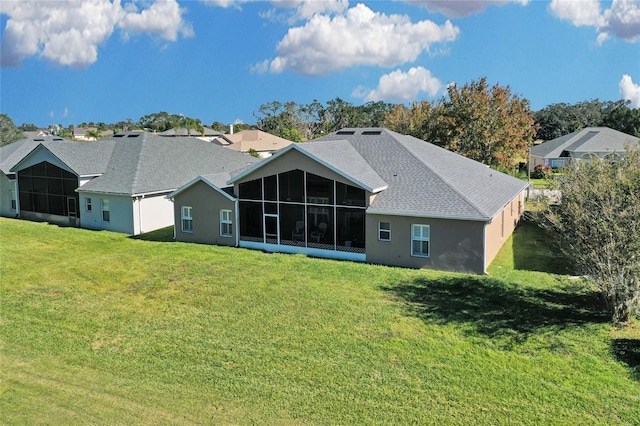 rear view of property with a sunroom and a yard