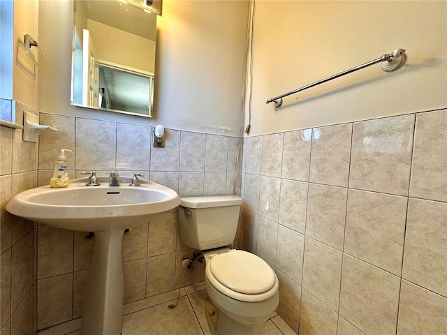 bathroom with toilet and tile walls