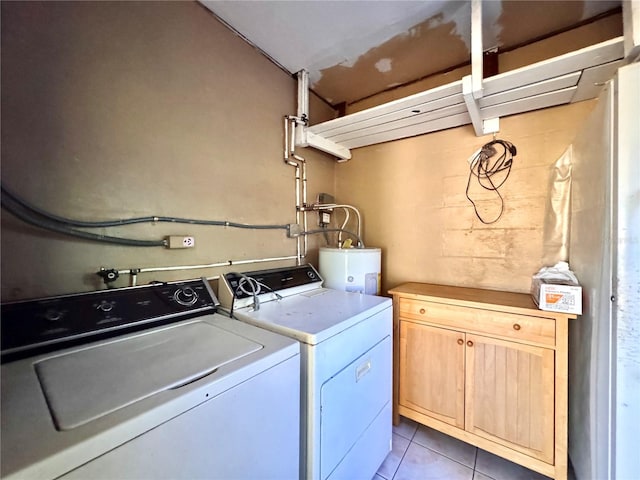 laundry area with electric water heater, light tile patterned floors, cabinets, and independent washer and dryer