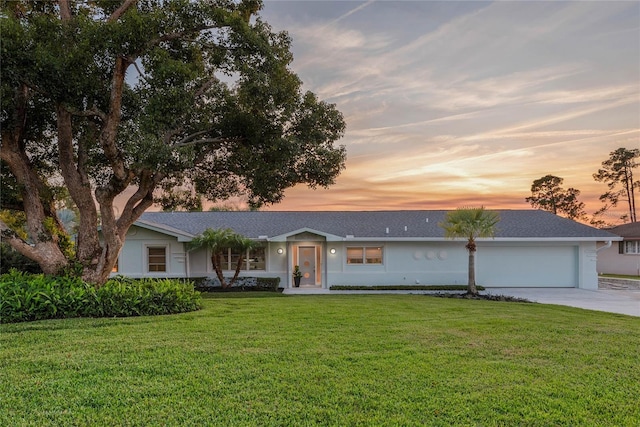 single story home featuring a lawn and a garage