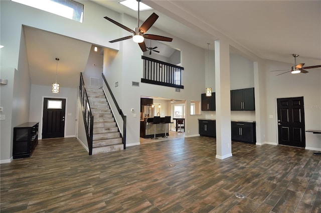 unfurnished living room with dark hardwood / wood-style flooring, lofted ceiling, and ceiling fan