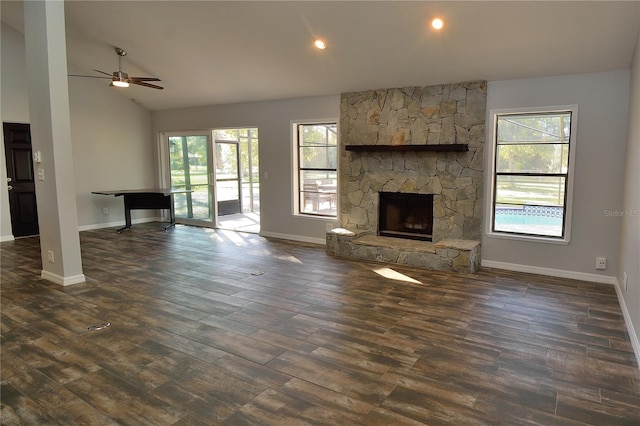 unfurnished living room with dark hardwood / wood-style floors, ceiling fan, a fireplace, and a wealth of natural light