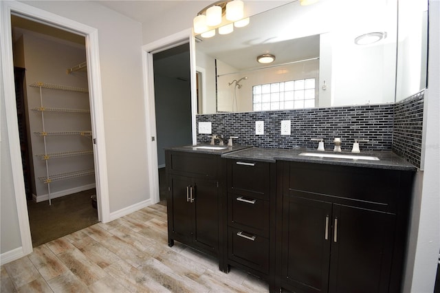 bathroom featuring vanity, decorative backsplash, and wood-type flooring