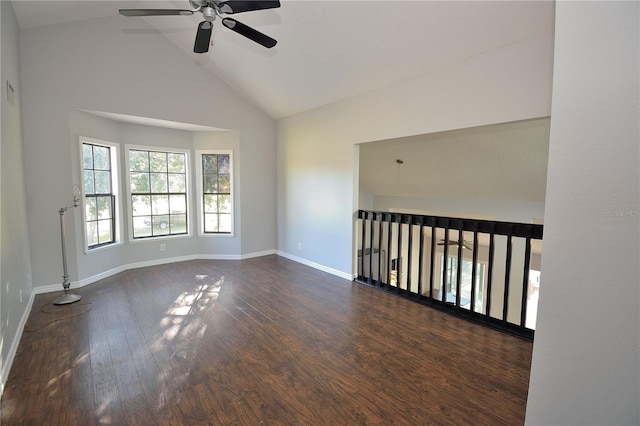 empty room with dark wood-type flooring, ceiling fan, and high vaulted ceiling