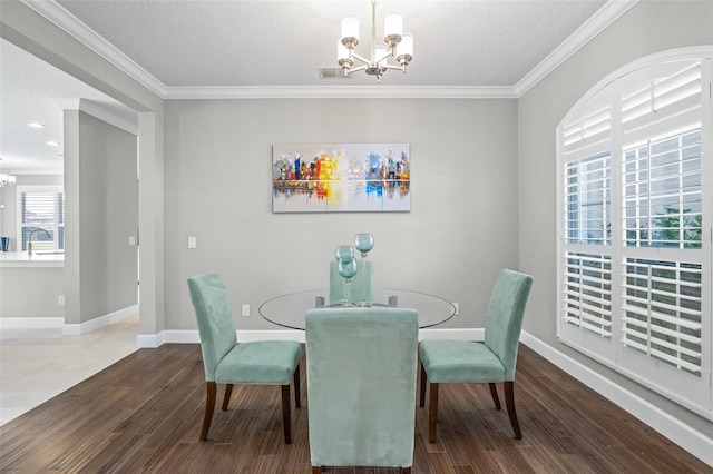 dining area with ornamental molding, a chandelier, a textured ceiling, and hardwood / wood-style flooring