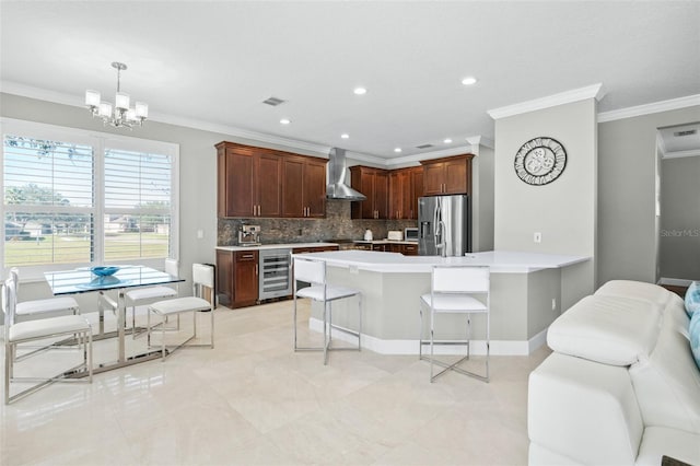 kitchen featuring stainless steel refrigerator with ice dispenser, backsplash, a breakfast bar, beverage cooler, and wall chimney range hood