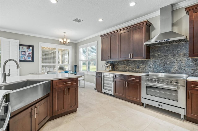 kitchen with wall chimney exhaust hood, wine cooler, a textured ceiling, stainless steel stove, and ornamental molding