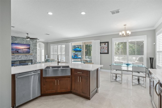 kitchen featuring sink, hanging light fixtures, stainless steel dishwasher, a textured ceiling, and ceiling fan with notable chandelier