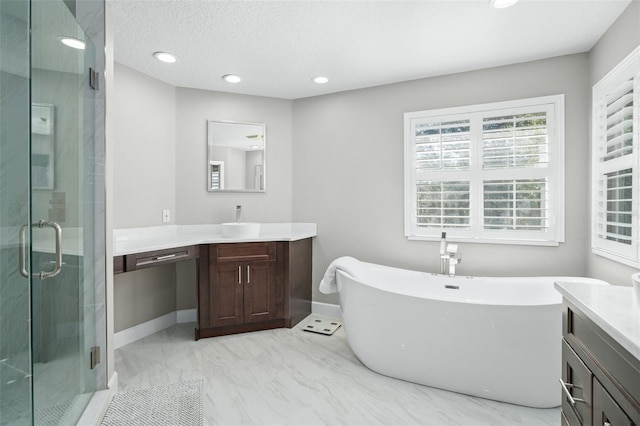 bathroom with vanity, a textured ceiling, and independent shower and bath