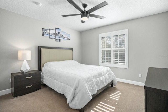 bedroom with a textured ceiling, light colored carpet, and ceiling fan