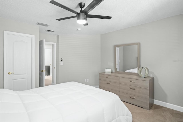 carpeted bedroom with ceiling fan and a textured ceiling