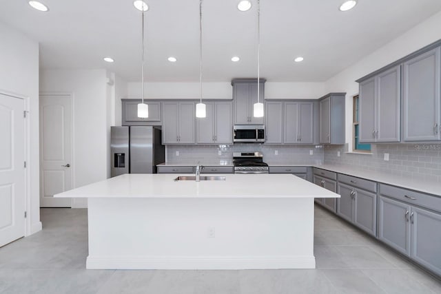 kitchen featuring decorative light fixtures, an island with sink, and appliances with stainless steel finishes