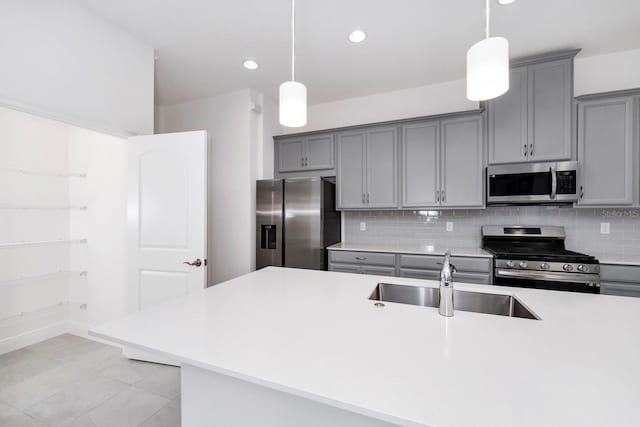 kitchen with pendant lighting, decorative backsplash, sink, and stainless steel appliances